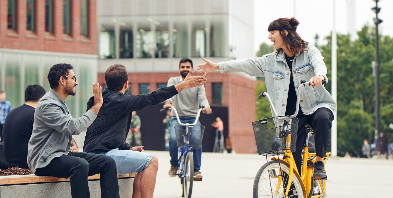 Students high-five-ing in front of the campus